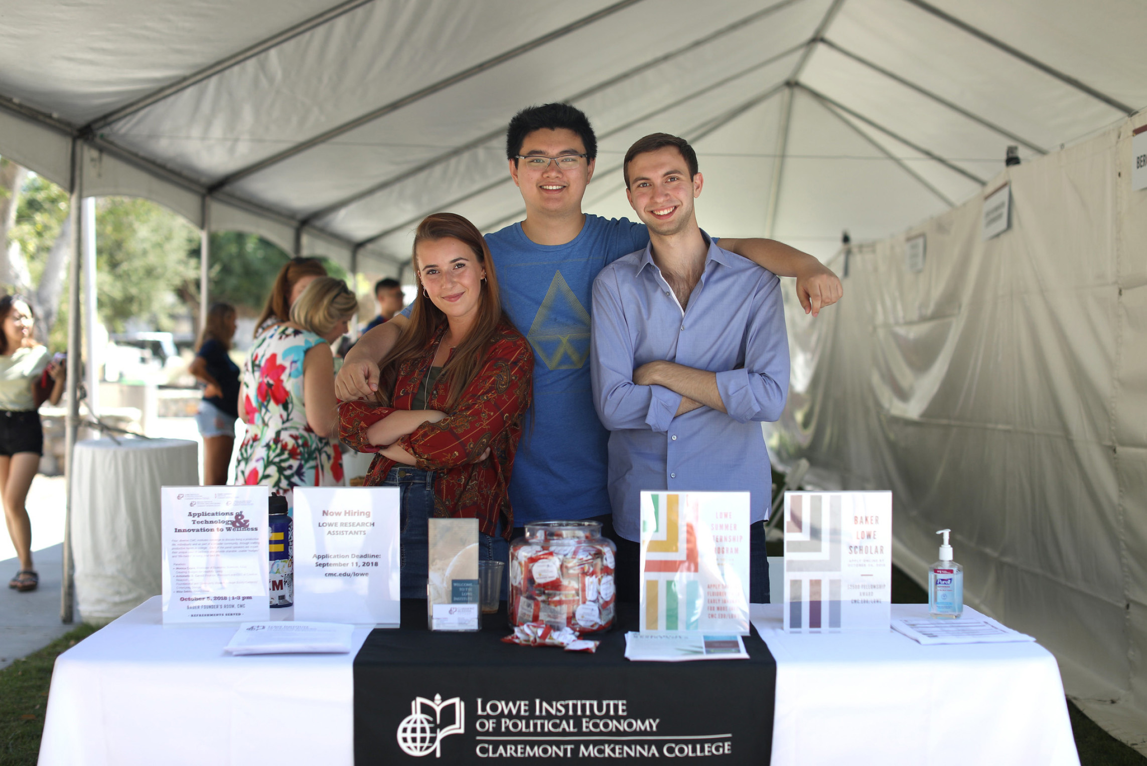Three students tabling for the Lowe Institute during the Engagement Fair.