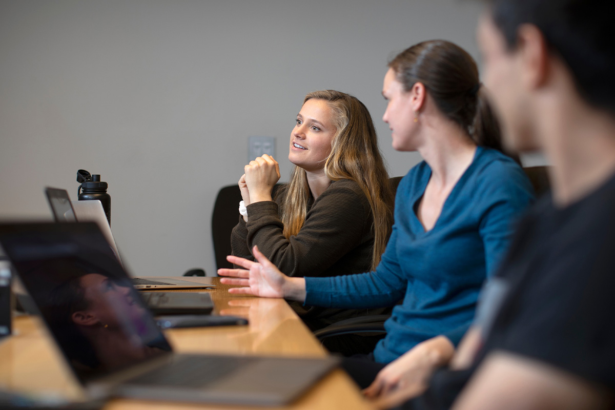 A student in focus asking a question during lecture.