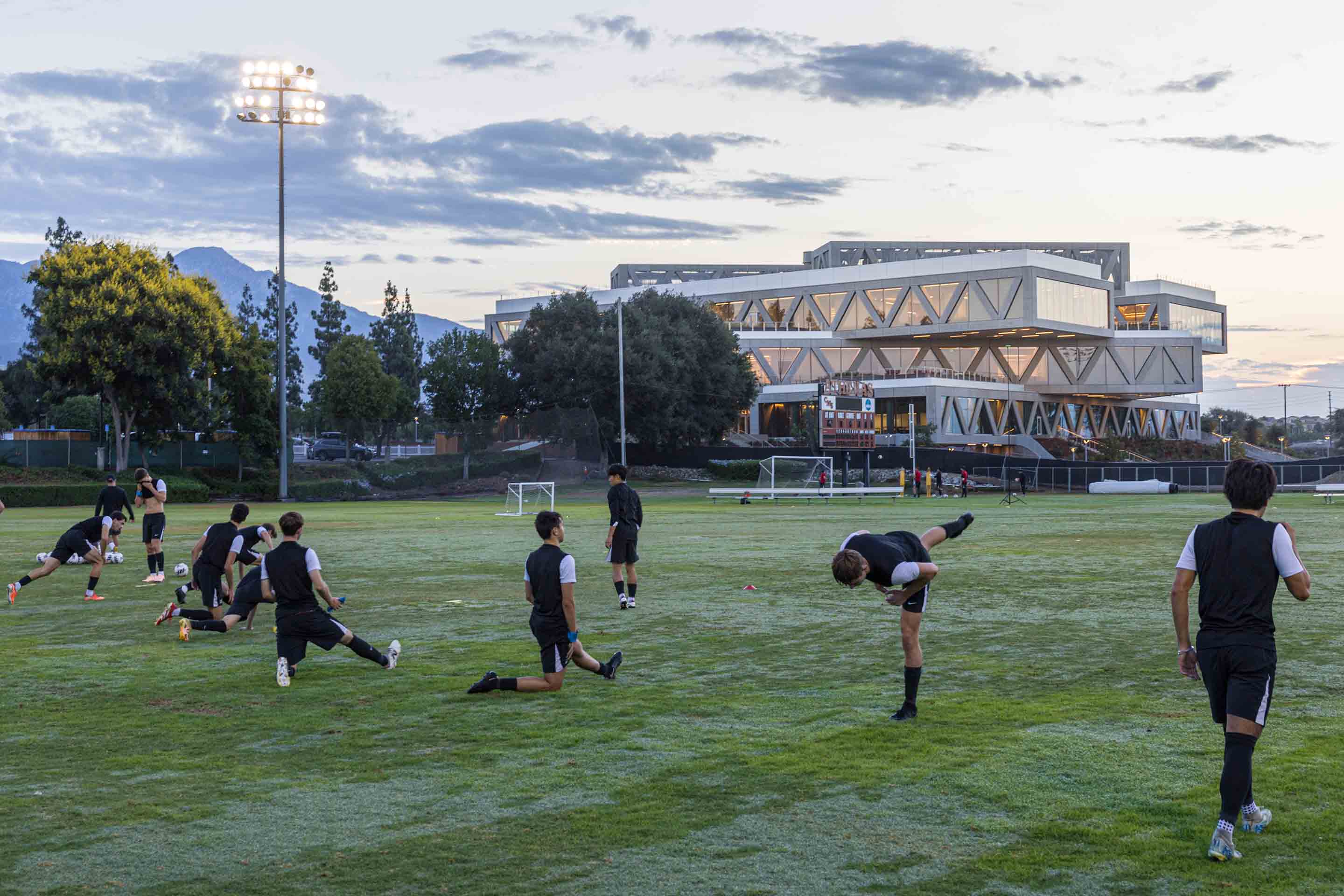 Soccer players practice on the field in front of the Robert Day Sciences Center