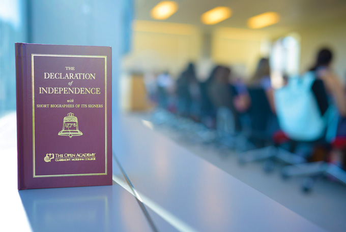 An Open Academy-branded Declaration of Independence in the foreground of a class in session.