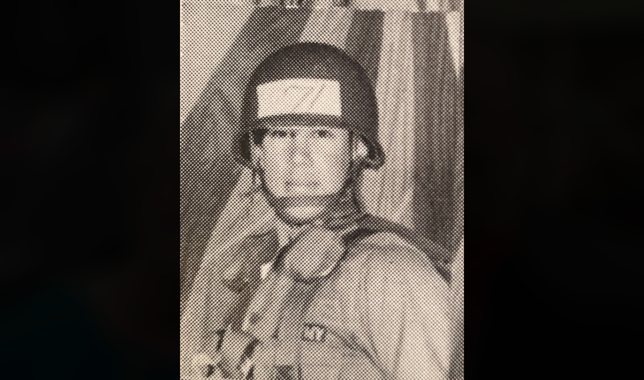 Man in khaki military clothing and gear with hard hat on.