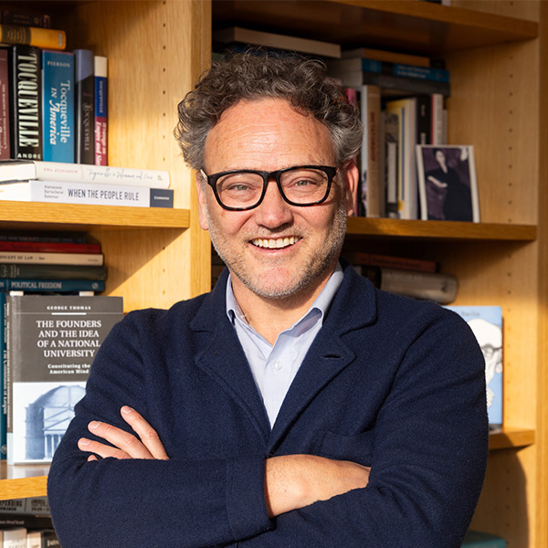 Professor George Thomas photographed in front of bookshelves in his office.