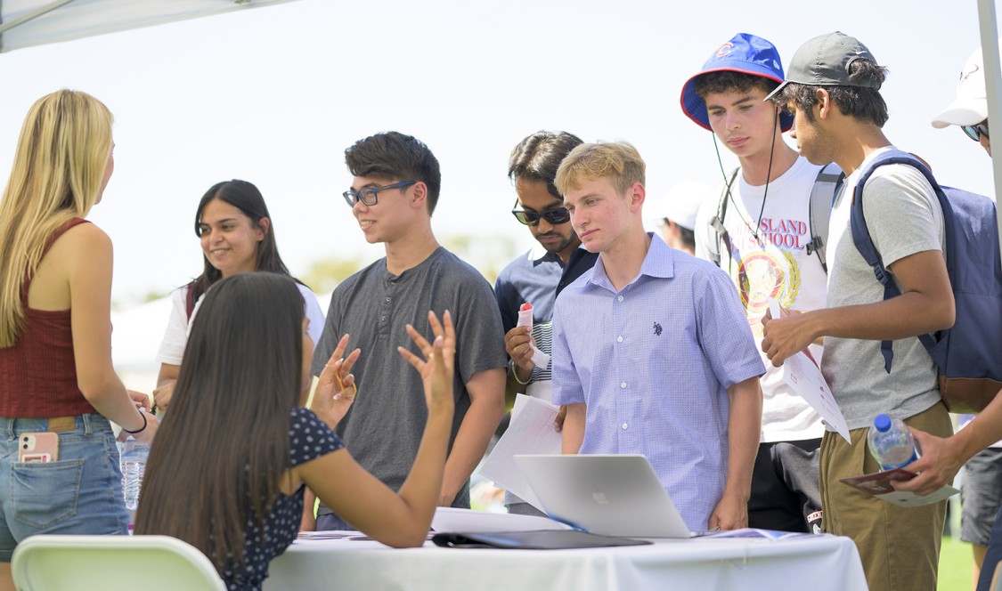 Students find snacks, drinks and shelter from the sun as they move from booth to booth
