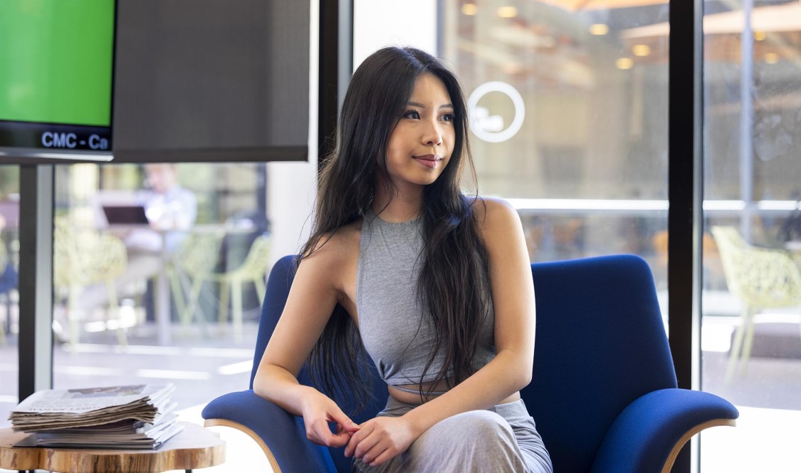 Nicole Chueng ‘25 seated on a blue chair.