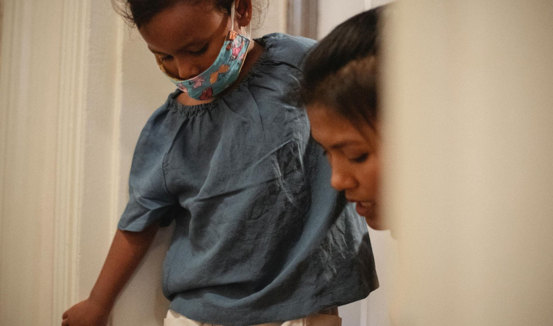 A woman is helping a child put on their shoes.