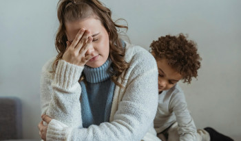 A woman holding her head in her hand in frustration.