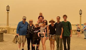 Mixed group of men and women standing in outdoors summer clothing.