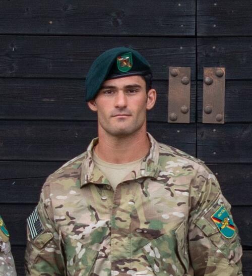 Man in military uniform wearing green beret.