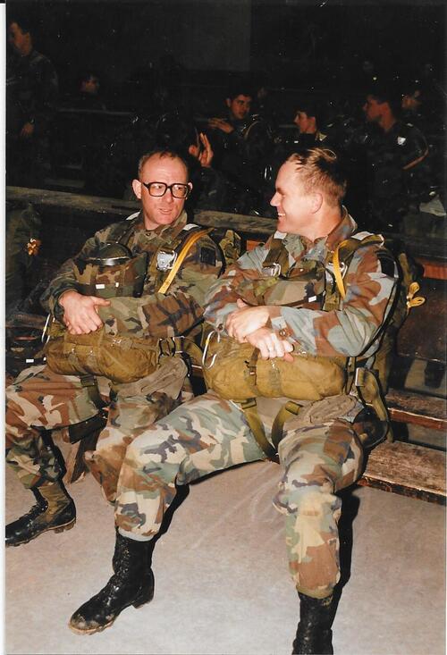 Two men sitting chatting in full military uniform.