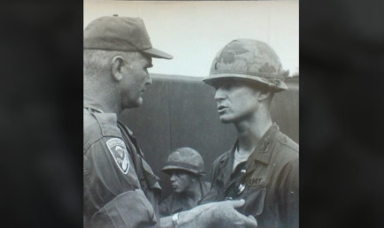 Black and white photo of Gilbert Ferrey '64 receiving a military award.