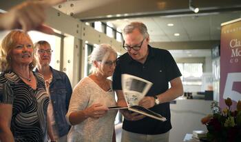 Class of 1980 classmates looking at yearbook